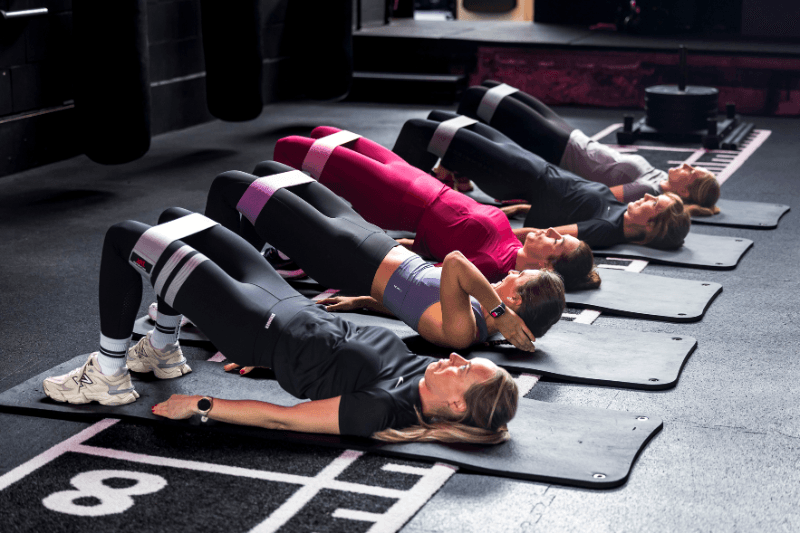 een groep dames die grondoefeningen doen